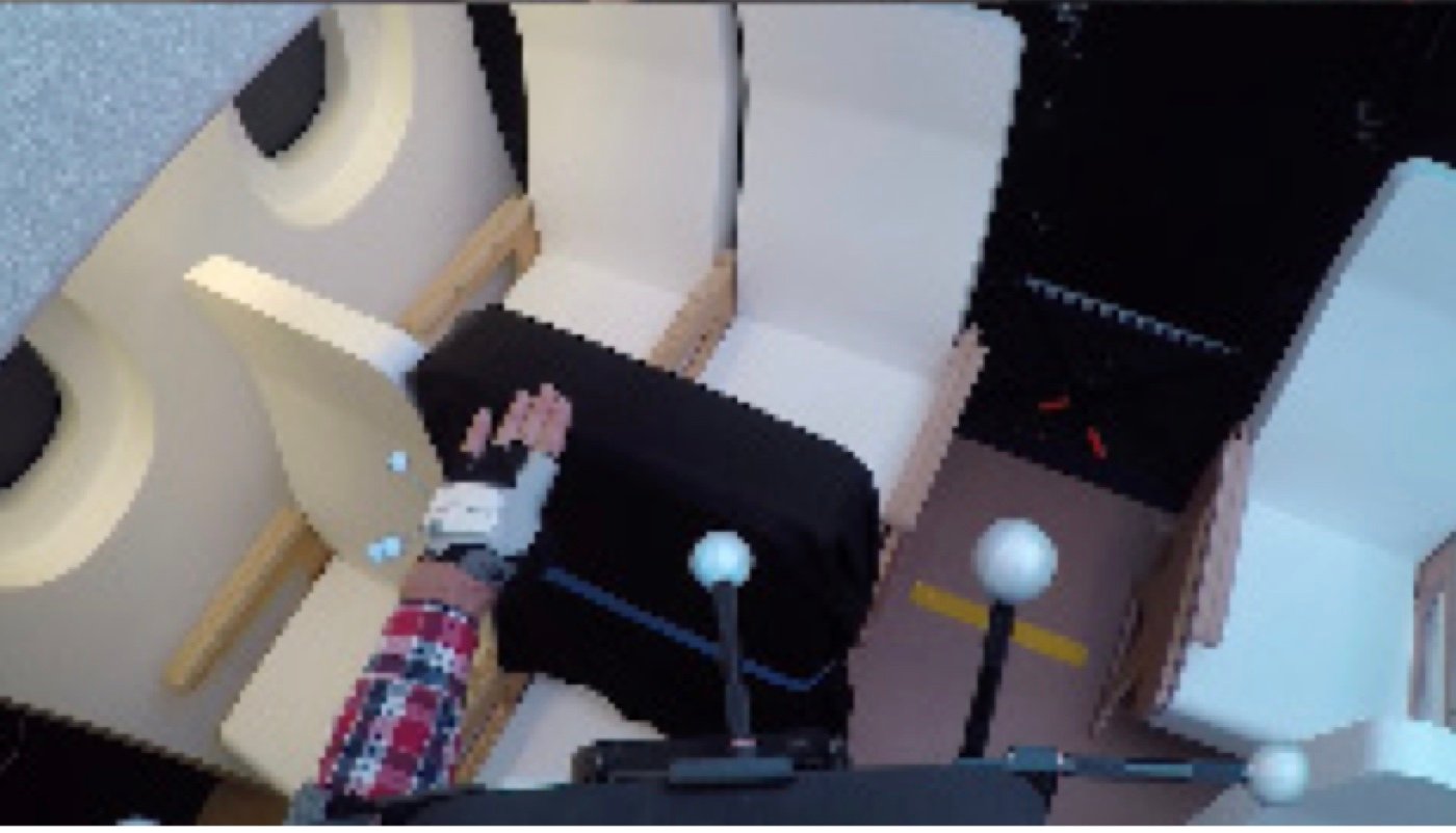 Overhead view of a dark physical aircraft cabin mockup with reflective motion-tracking markers